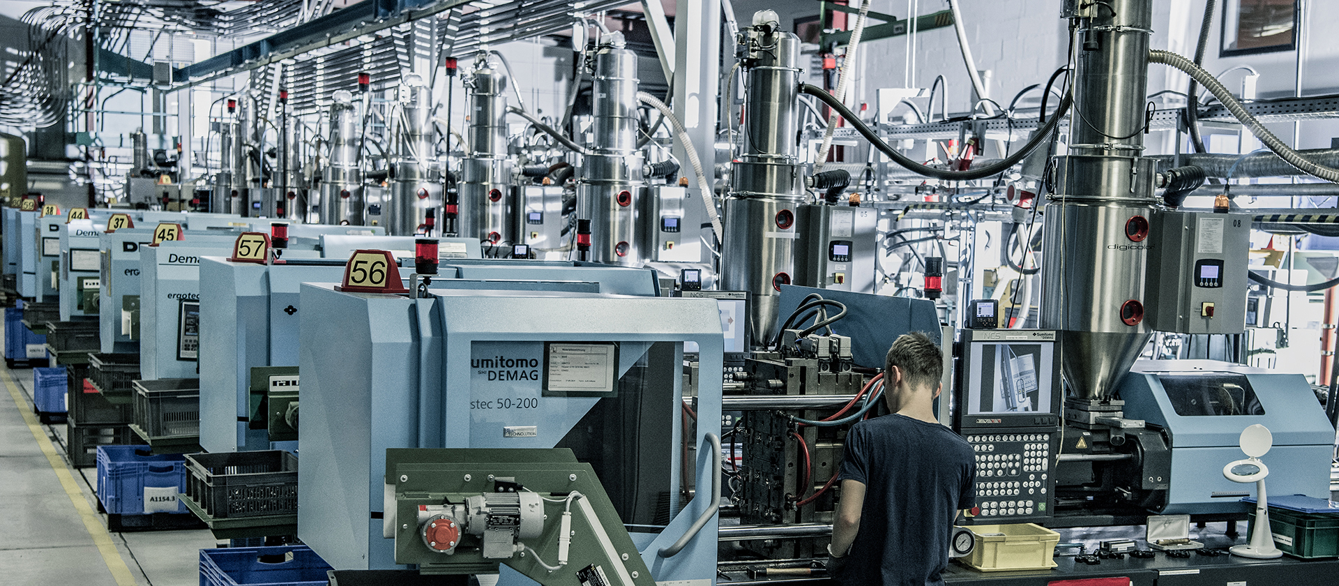 Materialzufuhrsystem in der Fertigungshalle der hankensbütteler kunststoffverarbeitung, das die Spritzgussmaschinen automatisch mit Kunststoffgranulat versorgt